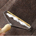 Brosse anti-poils MALYA à manche en bois qui regroupe les poils d'animaux sur un tapis