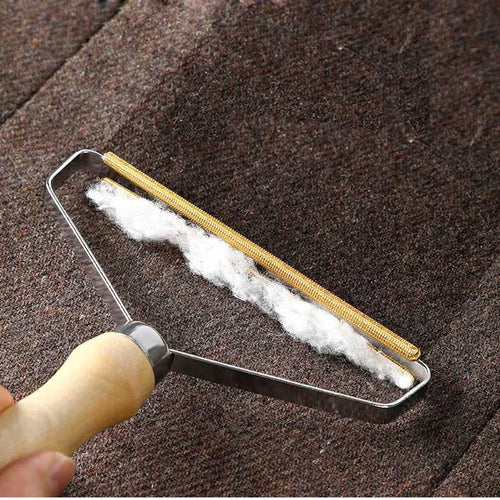 Brosse anti-poils MALYA à manche en bois qui regroupe les poils d'animaux sur un tapis